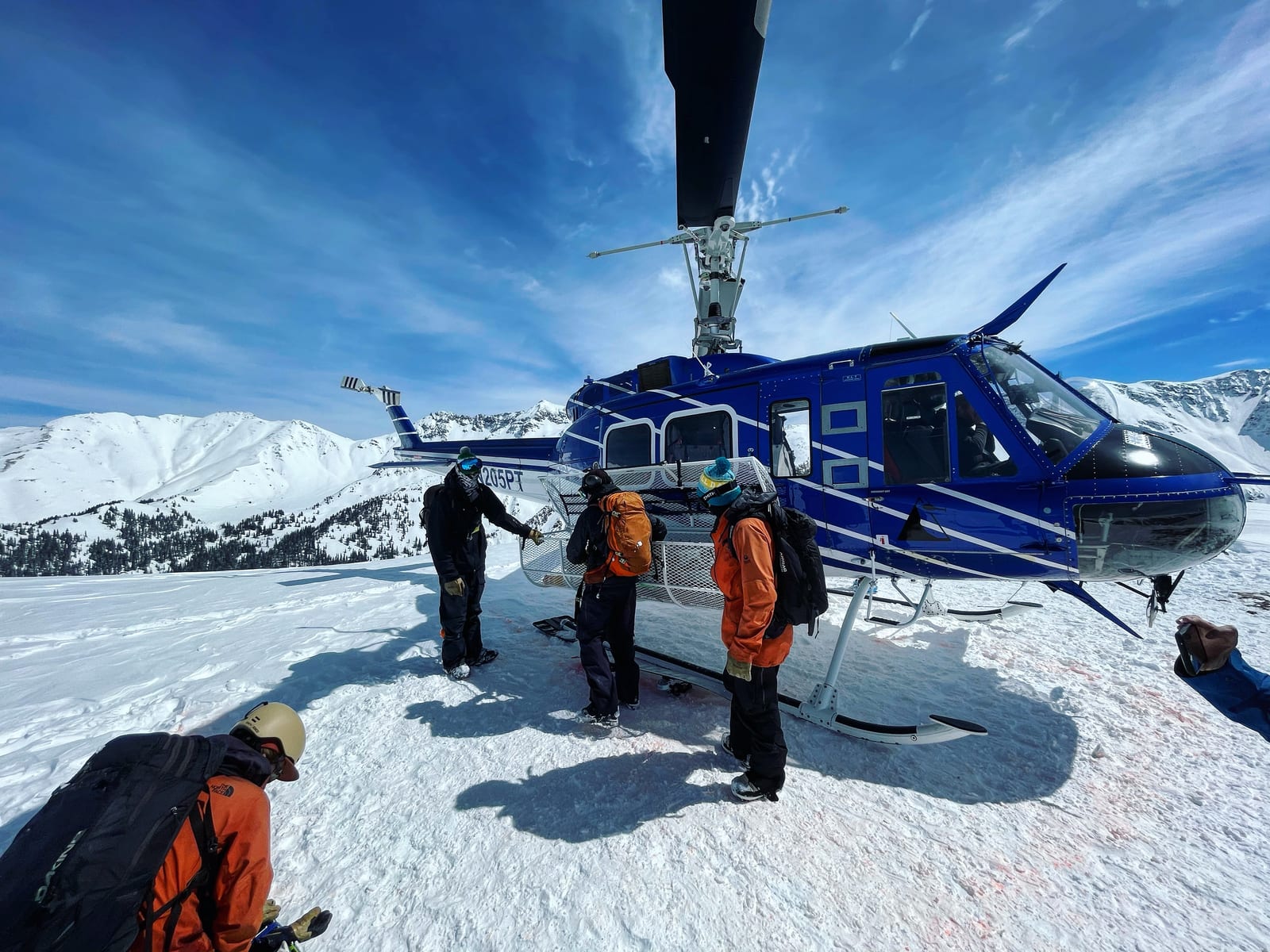 A heli-ski chopper on a snowy backcountry ridge