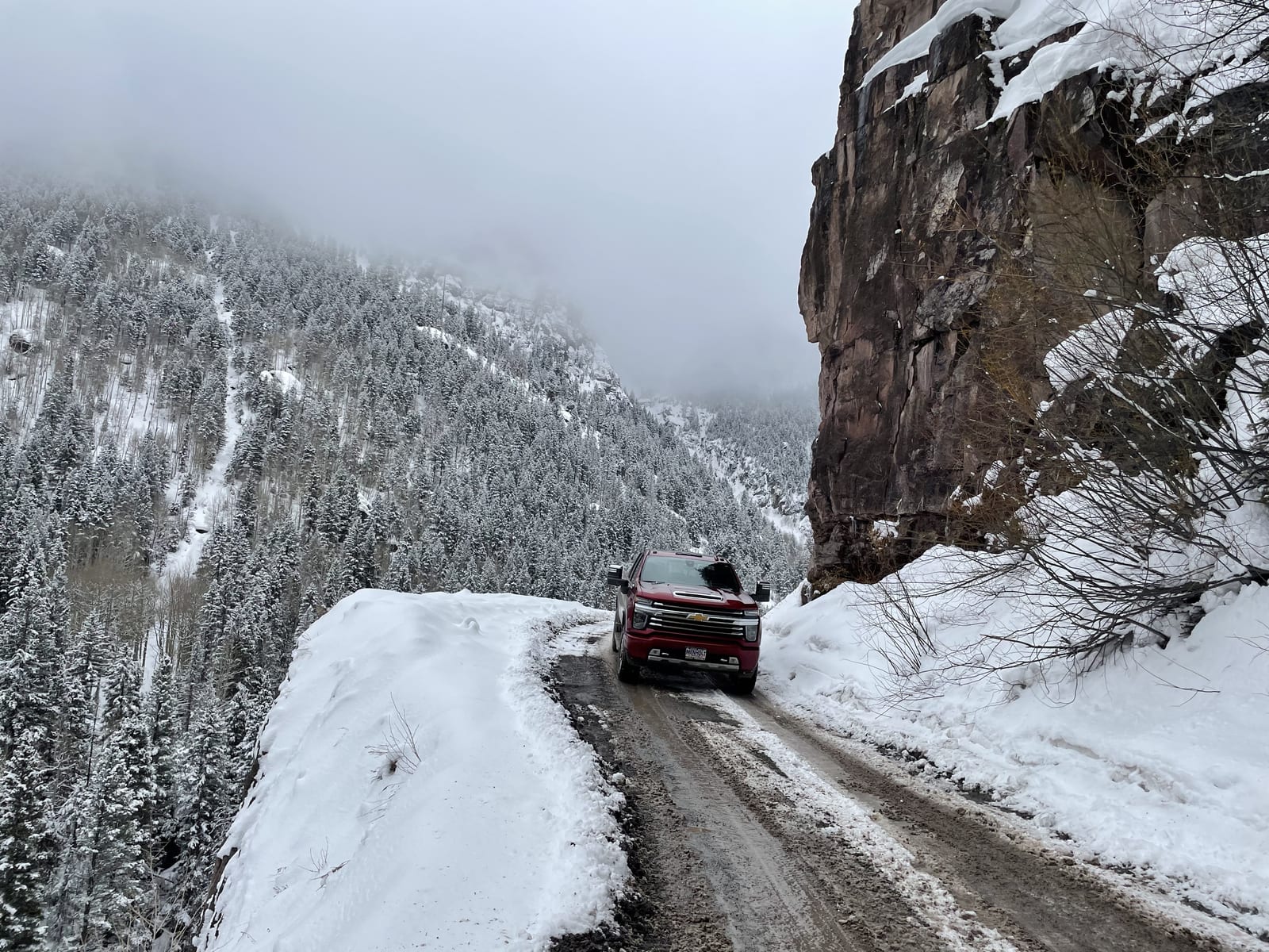 The truck on a snowy mountain shelf road in the San Juans