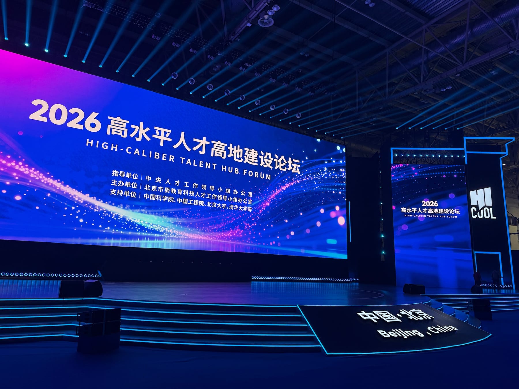 The HICOOL main stage in Beijing with a large blue screen reading 2026 High-Caliber Talent Hub Forum.